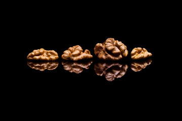 Four walnuts on black reflective background