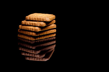 Five biscuits on black reflective background