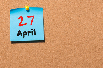 April 27th. Day 27 of month, calendar on cork notice board, business background. Spring time, empty space for text