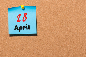 April 28th. Day 28 of month, calendar on cork notice board, business background. Spring time, empty...