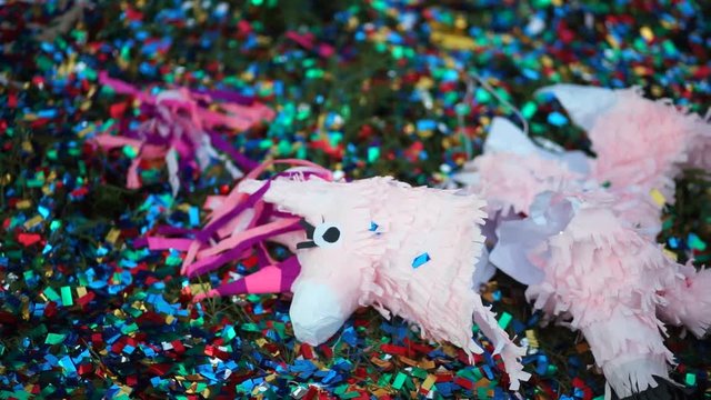 Broken pinata in the form of a horse lying on the grass.