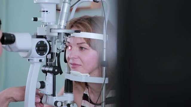 Modern medical procedure. Ophthalmologist points at touchscreen during eye examining. HD.