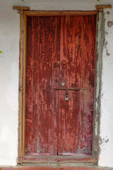 closed old red wooden door. Mediterranean style exterior.