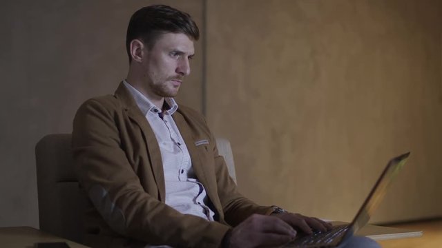 Businessman is looking in amazement at his laptop computer.