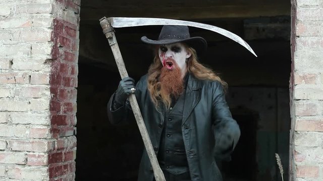 Scary killer man, holding a scythe in his hand to kill.