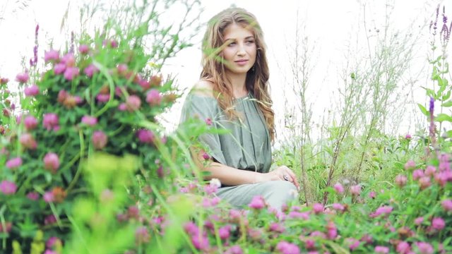 beautiful girl sitting in clover in nature, outdoors