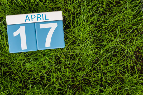 April 17th. Day 17 of month, calendar on football green grass background. Spring time, empty space for text
