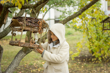brunette girl in a light coat with a hood in yellow autumn leave
