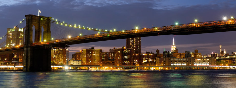 Panoramic image of the Brooklyn Bridge illuminated at night