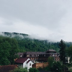 mountain forest and village shrouded in fog after rain