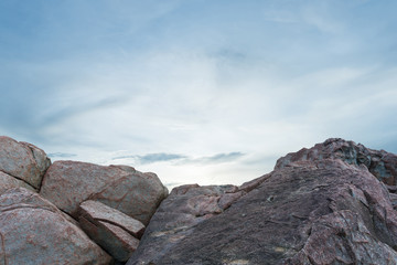 Pile of rocks boulders on sunset sky background