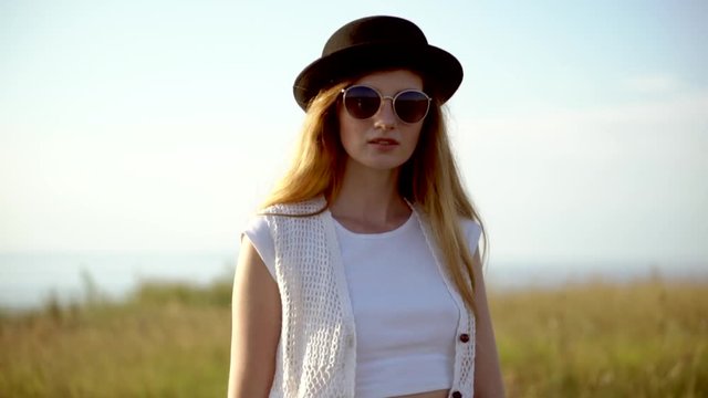 Young beautiful woman model in hat and sunglasses posing outdoor slow motion HD
