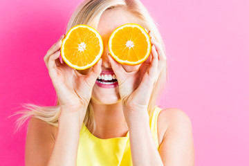 Happy young woman holding orange halves