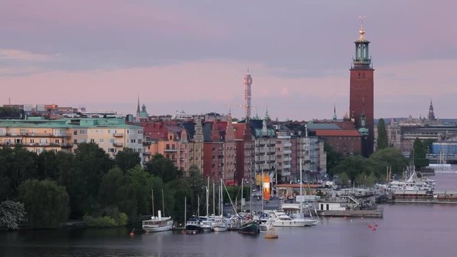 Stockholm landscape at twilight with City Hall, buildings, harbor and docks.