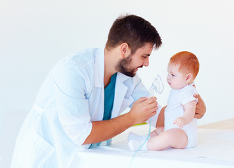 infant baby receives a nebulizer treatment through the facial mask © Olesia Bilkei