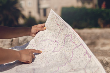 Woman traveler with map in old town at daytime