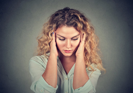 sad woman with worried stressed face expression looking down