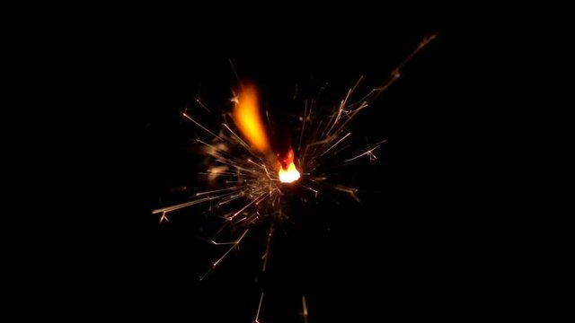 Sparkler burning over black background. Slow motion