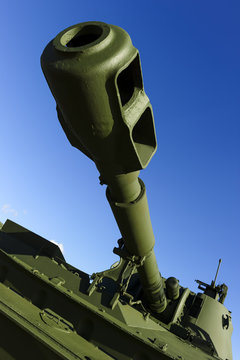Cannon barrel of powerful green tank with blue sky on background, modern army artillery, military industry, selective focus 