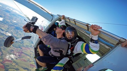 Skydiving tandem at the door of the plane