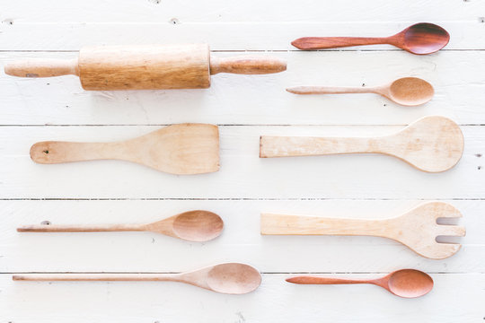 Wooden kitchen utensils on white  wooden background
