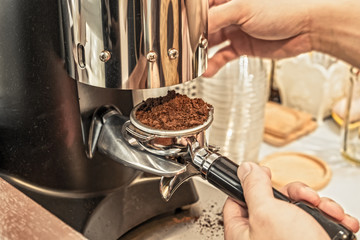 Hands holding coffee grinder powder