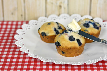blueberry muffins with knife on butter
