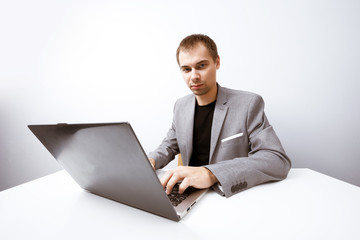 Handsome businessman works with laptop in office