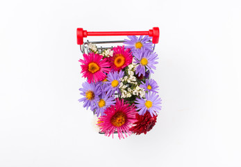 Shopping cart full of different wildflowers on white background