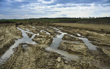 Düstere Landschaft mit Baustelle und tiefen Reifenspuren im Sch