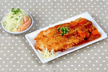 Deep fried dolly fish (Crispy) in Japanese style topped yellow curry with side dish as sliced cabbage and pickled ginger are very delicious