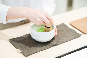 Whisking matcha powder by a chasen
