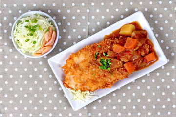 Deep fried dolly fish (Crispy) in Japanese style topped yellow curry with side dish as sliced cabbage and pickled ginger are very delicious