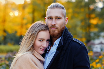 Fototapeta premium Redhead bearded male hugs the cute blonde female.