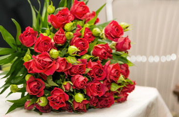 Beautiful wedding bouquet made of small red roses and green leaves