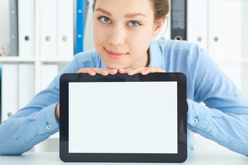 Closeup portrait of a young beautiful business woman showing blank screen of tablet computer.