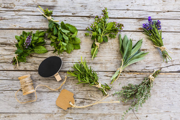 Fresh and aromatic herbs in bunches on old wooden table. 