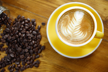 a cup of coffee latte art  with foam over wooden table, top view