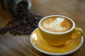 coffee cup  of coffee latte art and coffee beans on old wooden b