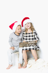 Fototapeta premium Christmas kids in Santa hat on white background