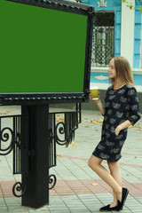 Beautiful girl looks at a billboard