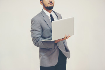 Young businessman thinking with laptop