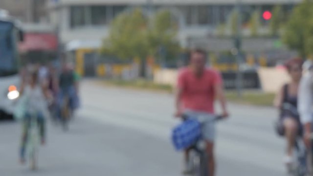 Real time blurred locked down establishing shot of commuters on bikes nearby Alexanderplatz neighborhood in Berlin, Germany.
