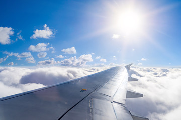 Naklejka na ściany i meble Wing of an airplane above the clouds