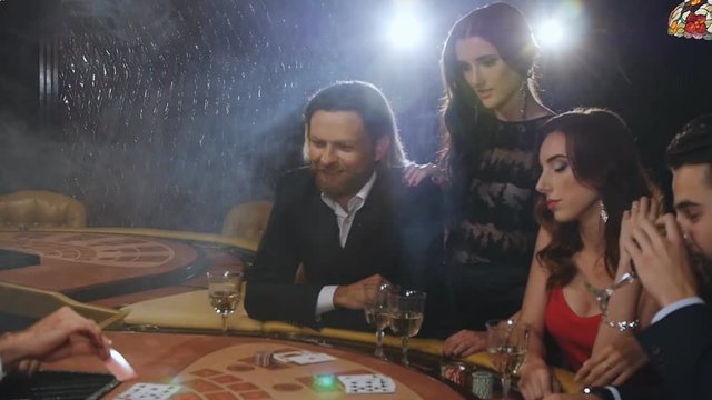A group of young and beautiful people drinking champagne and playing blackjack
