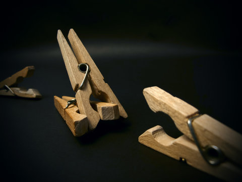 Aggressive clothespins. Fighting of wooden clothespins on dark background. Illustration aggression issues. Part of photoset.