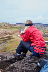 woman hiker photographer taking picture on the mountains background in Iceland