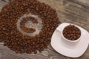 small white cup, the letter c made from coffee beans on wooden background