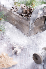 Christmas composition with wooden box with pinecone, gifts and decoration on snow. Christmas greeting card with copy space.