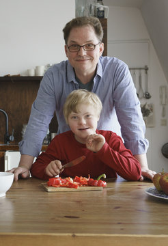 Portrait of father and boy at table in kitchen
